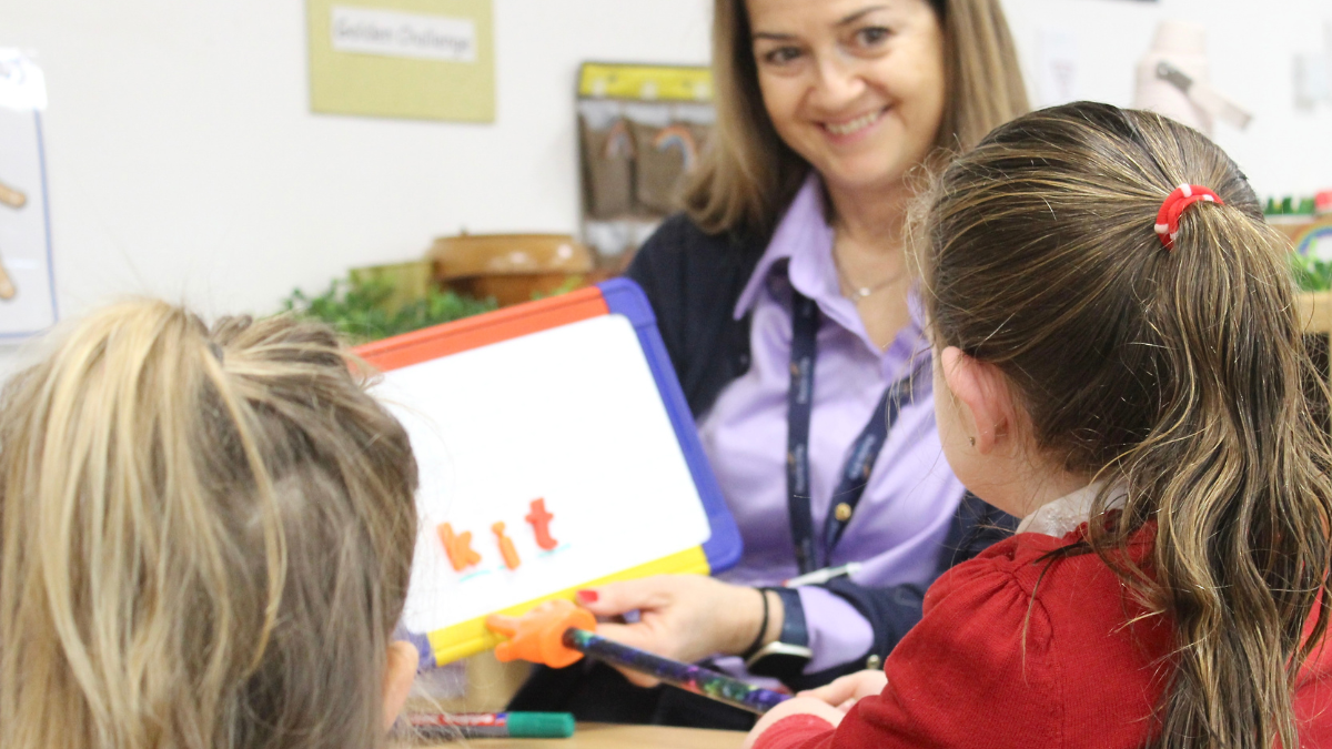 Teacher with two students in phonics lesson