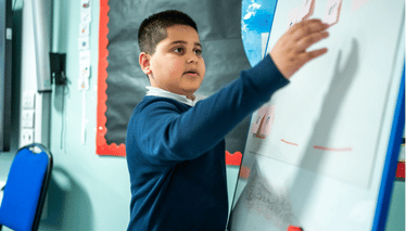 Student making a word with sticky notes on the whiteboard
