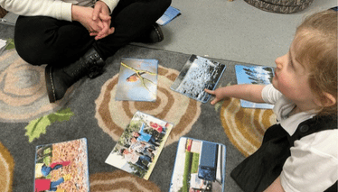 Child pointing at pictures and discussing with adult
