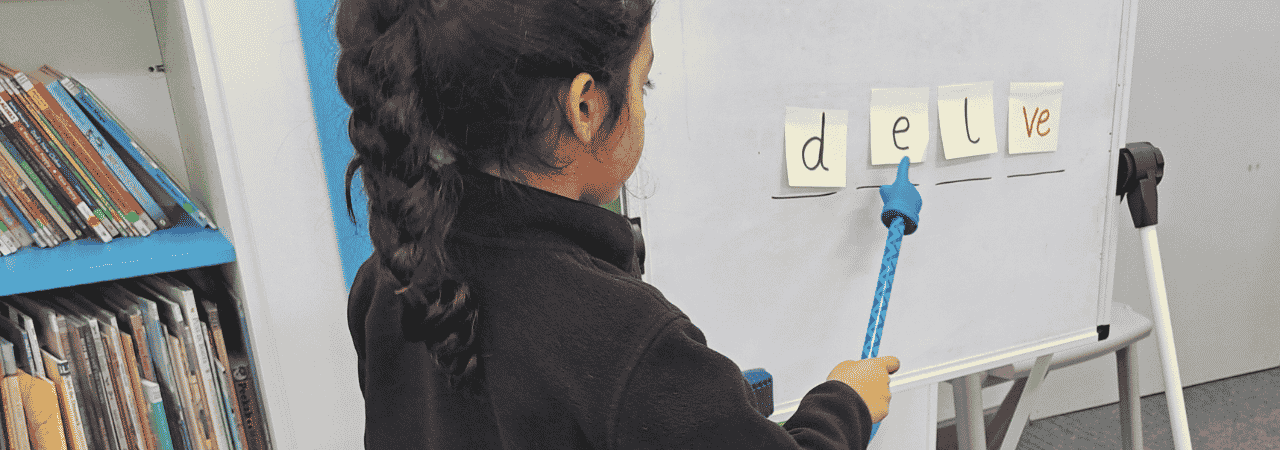 Girl points at the sounds on a whiteboard